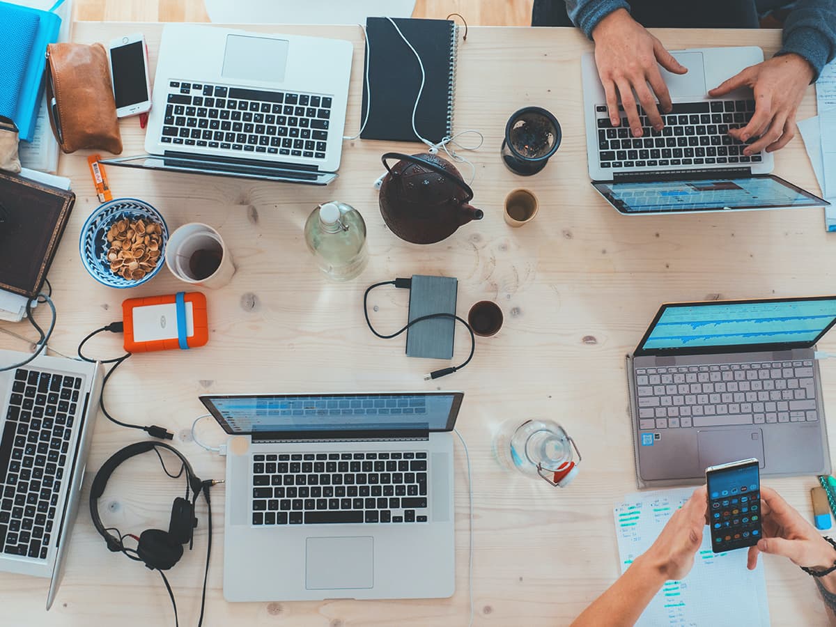 People working together on desk with different devices